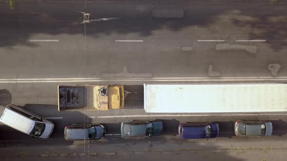 Aerial top down view of busy city street with traffic cars during rush hour.