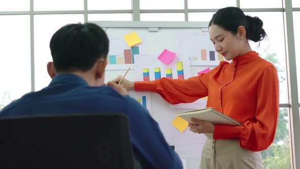 Young Woman Explains Business Data on White Board