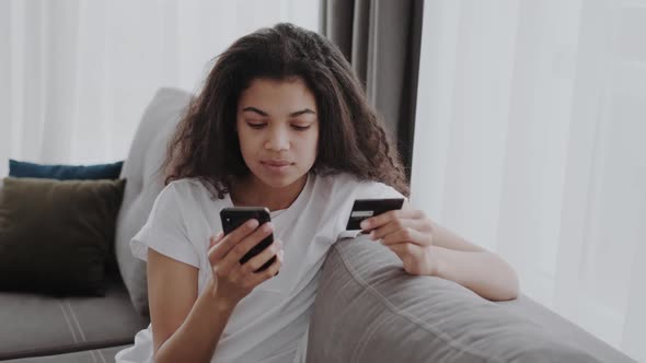 A Credit Card and Smartphone in Female Hands