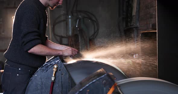 Bladesmith wet grinding a blade