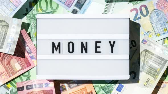 Zoom in Out Lightbox Board with the Word MONEY in Black Letters Around Euro Banknotes