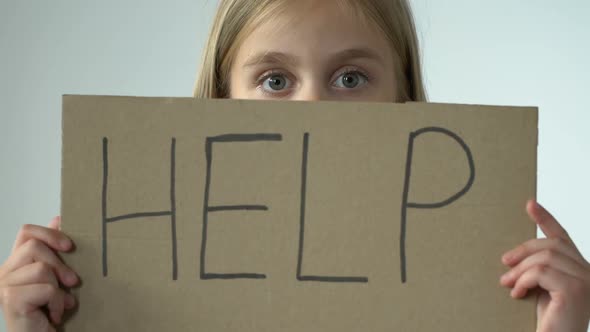 Help Word on Poster in Hands of Scared Little Girl, Bullying Abuse Awareness