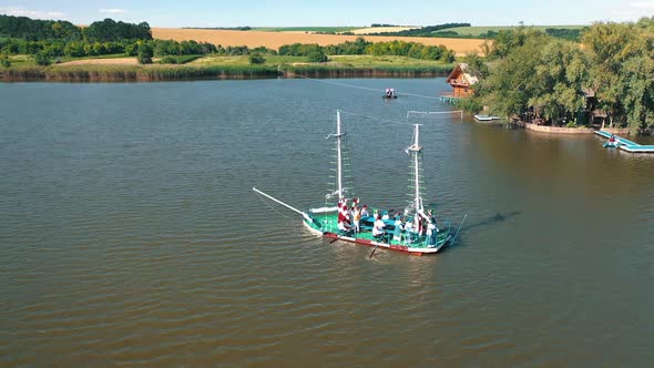 Old boat floating near the island with house in the river