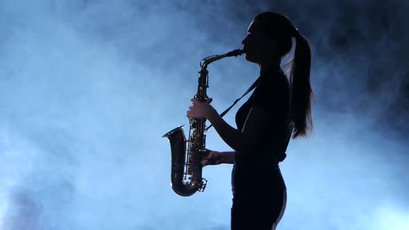 Silhouette Professional Musician Female Playing on Saxophone. Smoky Isolated Studio
