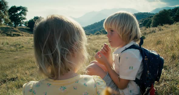 Children on Summer Mountain Vacation Trip Sitting on Hill Eating Cherry Fruit