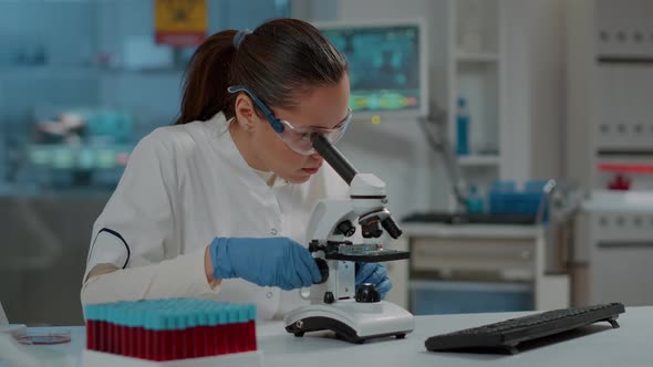 Portrait of Scientist Looking Through Microscopic Lens in Laboratory