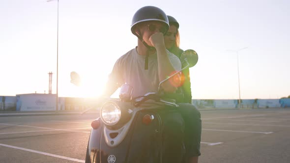 Happy Young Couple Riding Vintage Scooter on Urban Background and Having Some Fun Slow Motion