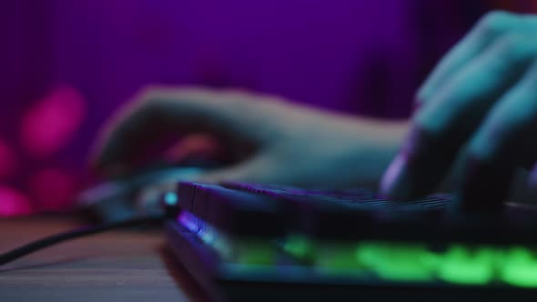 Gamer Typing on Backlight Keyboard Closeup Man Playing Video Game