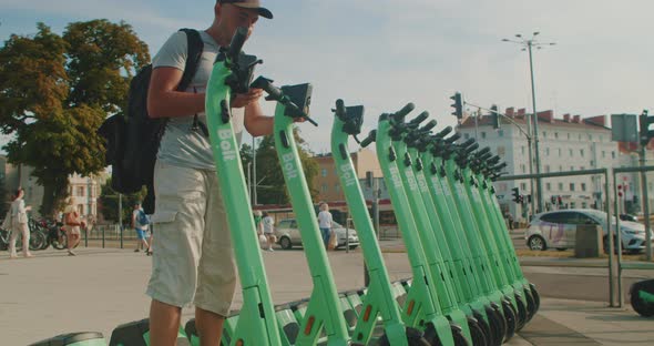 A Young Male Tourist Rents an Electric Scooter Using an App