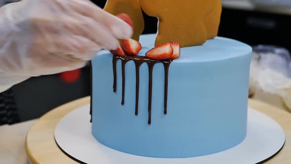 Pastry Chef Decorates Blue Cake with Strawberries Chocolate and Cookie Shapes