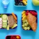 Shot of School Lunchboxes with Various Healthy Nutritious Meals on Blue Background - VideoHive Item for Sale