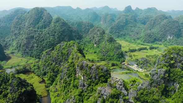 Aerial: North Vietnam karst landscape at sunset, drone view of Ninh Binh region, tourist destination