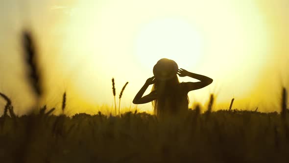 Silhouette of Girl Watching Sunset in Wheat Field