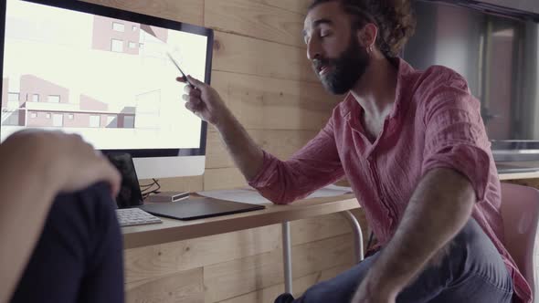 Architects speaking about project in front of computer screen