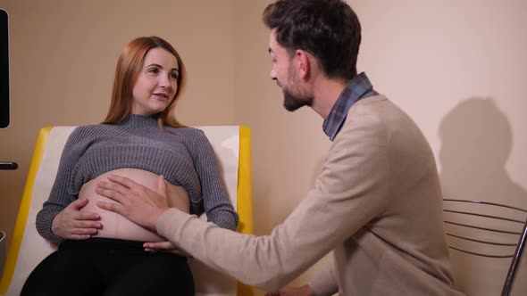 Man Stroking and Kissing Belly of Pregnant Woman