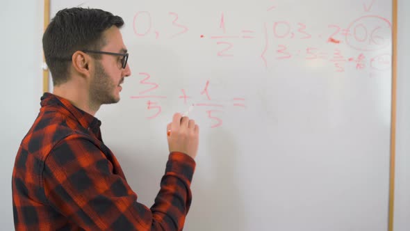 Young Teacher in Red Shirt and Glasses Teaching Maths Remotely Online 