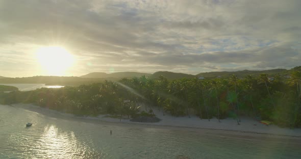 Aerial of bright light over sea and palm trees on coast, Cap Chevalier