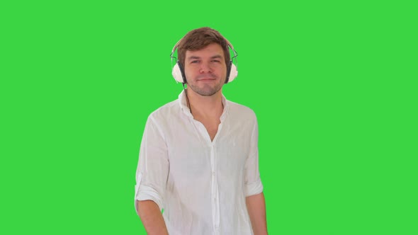 Casual Young Man Listening To Music Headphones While Walking Looking Camera Green Screen Chroma Key