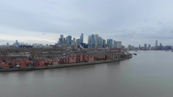 Rising drone shot towards Canary wharf Isle of dogs over thames river London