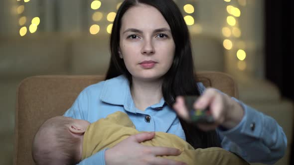 Mother with Newborn Boy Watching Television at Home