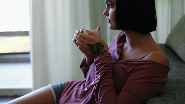 Woman Having Coffee in Living Room 