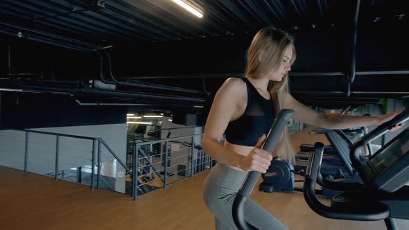 Lady Making Workout on Orbitrek in Gym