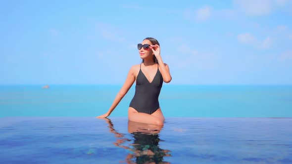 Young asian woman enjoy around outdoor swimming pool for leisure