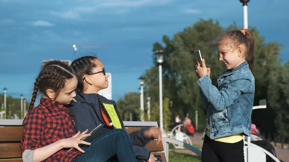 A Group of Children Sitting on a Bench