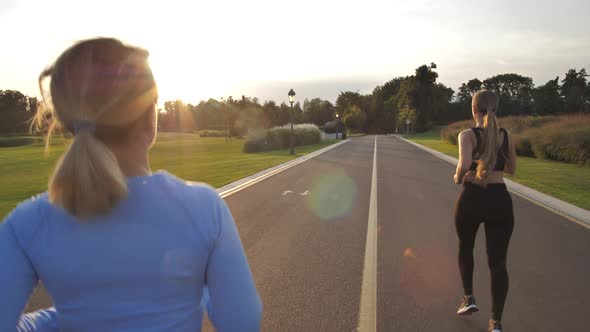 Blonde Sporty Women Jogging in Park During Sunset
