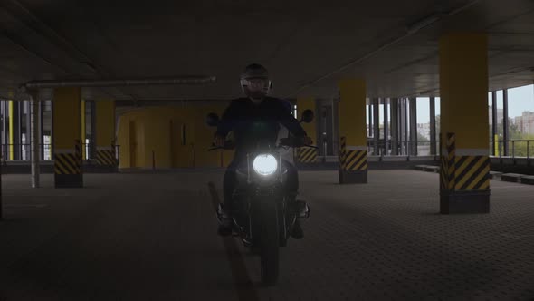 Man Riding Scrambler Motorbike Though Yellow Multilevel Parking