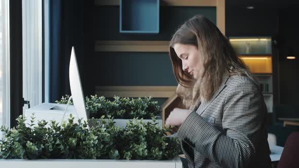 Successful Smiling Businesswoman Uses Laptop and Computer Used in the Office