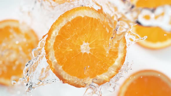 Water splash on sliced orange. Slow Motion.