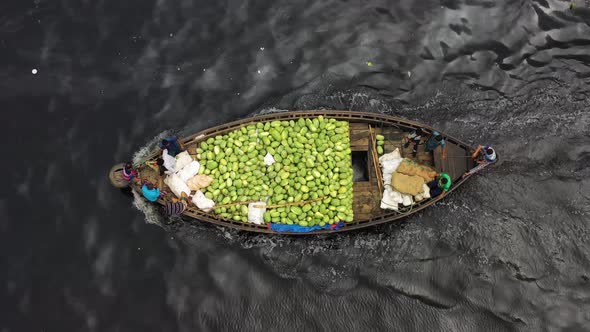 Aerial view of a Person carrying watermelons on boat along the Buriganga river.