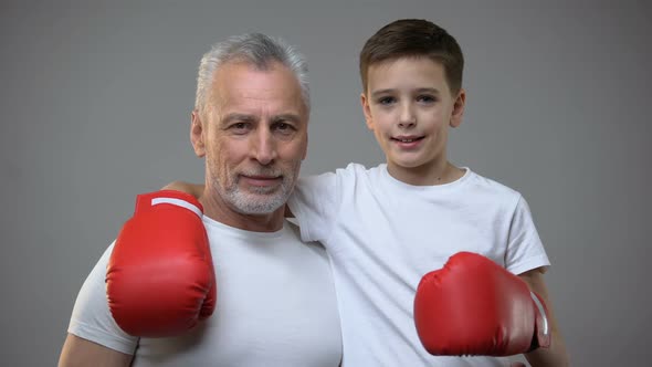 Active Senior Male and Boy in Boxing Gloves Looking to Camera, Healthy Lifestyle