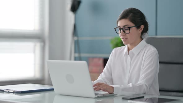 Indian Businesswoman Shaking Head as No Sign while using Laptop in Office