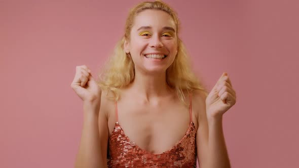 Blonde Woman Rejoicing Her Success and Victory Clenching Her Fists with Joy