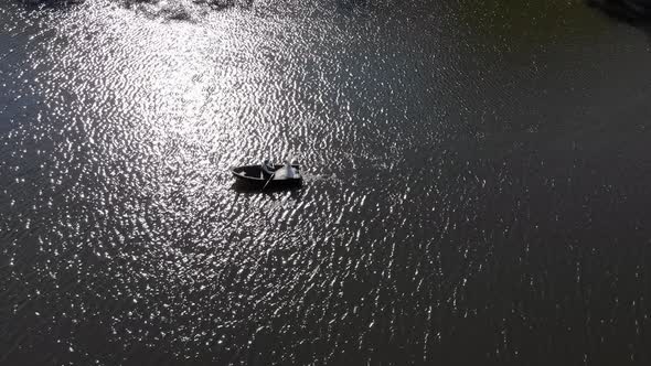 Aerial Shot of Brides Swim in a Red Boat. The Bright Sun Is Reflected in the Lake