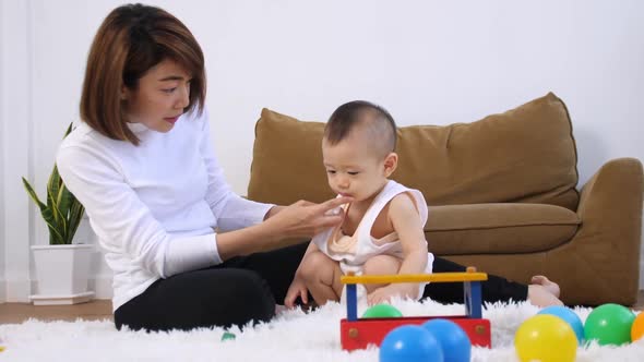 Young mother with her baby spending time together at home.