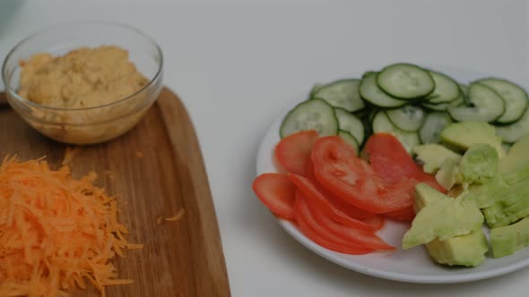 Close-up of chopped fresh vegetables and hummus. Cooking Salad.