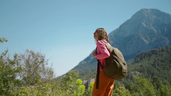 Slow Motion Closeup Portrait of Beautiful Young Woman Hiker Standing on Beautiful Mountain Landscape