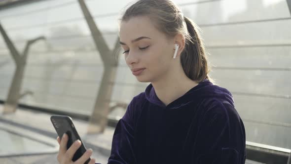 Happy Relaxed Caucasian Sportswoman Looking at Smartphone and Smiling