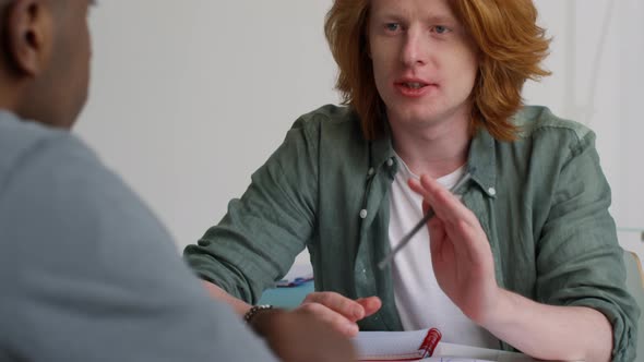 Young Redhead Millennial Talking to Colleagues