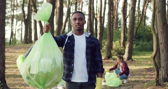 African American Cleaning Up the Park Territory from Rubbish Together with Team of Volunteers