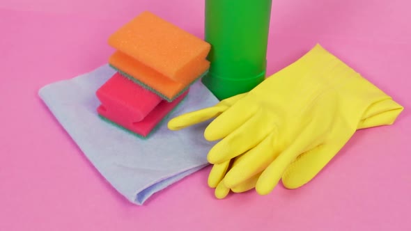 On a Pink Background a Bottle of Cleanser Latex Gloves and a Cleaning Cloth