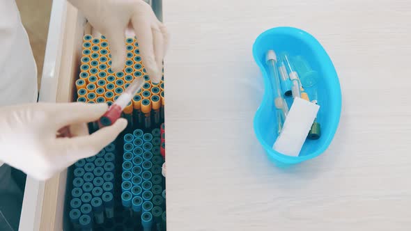 Nurse Takes Out Empty Test Tubes and Puts Them in a Tray for Transportation