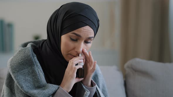 Muslim Arabian Woman Sick Islamic Girl in Hijab Sit on Cozy Sofa at Home Treating Runny Nose Use