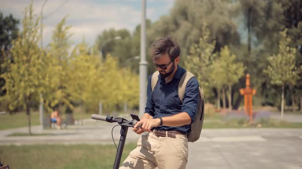 Male Drive Electric Scooter In City. Urban Style Riding Ecological Transport Travel. Driving Ecology