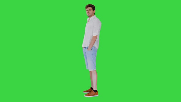 Casual Young Man Looking at Camera and Talking About Something on a Green Screen, Chroma Key