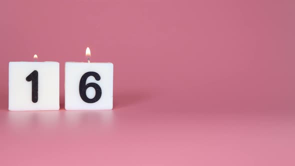 A square candle saying the number 16 being lit and blown out