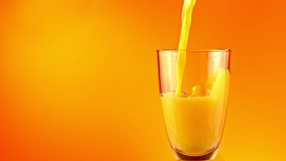 Super Slow Motion Shot of Pouring Fresh Orange Juice Into Glass at 1000 Fps